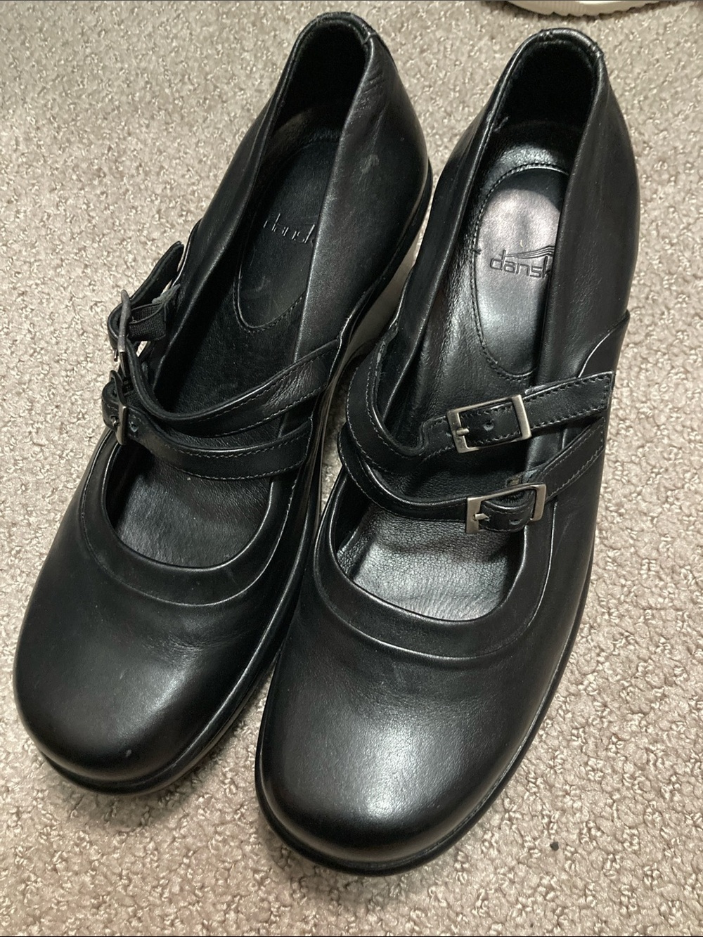 Dansko Mary Janes feature a distinctive double-strap buckle design